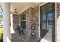 Charming brick-paved front porch featuring elegant columns and a cozy seating area by the front door at 930 Crestview Dr, Johns Creek, GA 30024