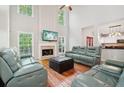 Bright living room features tall ceilings, a cozy fireplace, and expansive windows offering serene views at 8355 Ainsworth Dr, Cumming, GA 30041