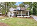 Beautiful home with a welcoming front porch, manicured lawn, and well-maintained landscaping at 159 Forest Ave, Social Circle, GA 30025