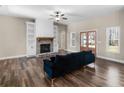 Inviting living room featuring a stone fireplace, built-in shelves, dark wood floors, and a comfortable dark blue sofa at 1847 Davis Mill Rd, Dallas, GA 30157