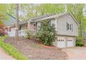 View of the home's rear exterior showing its garage and lush green surroundings at 2101 Kinridge Rd, Marietta, GA 30062