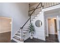 Bright foyer with stairs with black handrail, plant, and dark hardwood floors at 275 Sageglen Rd, Lawrenceville, GA 30044