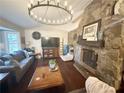 Bright living room with hardwood floors, stone fireplace, and stylish chandelier at 110 N River Rd, Mcdonough, GA 30252