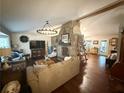 Open-concept living room featuring hardwood flooring, a stone fireplace, and stylish furnishings at 110 N River Rd, Mcdonough, GA 30252