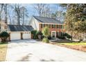 Traditional brick two-story home with three-car garage, mature trees, and manicured landscaping at 3762 Frederica Rd, Berkeley Lake, GA 30096