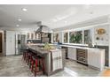 Spacious kitchen with stainless steel appliances, a center island, wine storage, and large windows at 3762 Frederica Rd, Berkeley Lake, GA 30096
