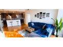 Bright living room with hardwood floors, blue sectional sofa, and cityscape artwork at 950 W Peachtree Nw St # 904, Atlanta, GA 30309