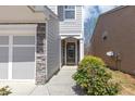 Charming front door with decorative stone accents and a well-maintained lawn, creating a welcoming entrance at 5780 Crestwick Way, Cumming, GA 30040