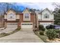 A home's exterior view shows the driveway and attached garages, and a well manicured yard at 875 Edgewater Cir, Marietta, GA 30062