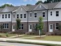 Modern townhomes featuring brick and siding exteriors with well-kept lawns at 1250 Ainsworth Aly # 42, Sugar Hill, GA 30518