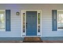 Classic front door with sidelights and decorative hardware, framed by elegant blue shutters at 2887 Swarthmore Dr, Lawrenceville, GA 30044
