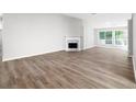 Bright and spacious living room with hardwood flooring, a fireplace, and large windows at 1590 Highland Farm Dr, Suwanee, GA 30024