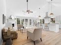 Open-concept living area showcasing a fireplace, bright kitchen, and dining space at 3407 Deerwood Ct, Rex, GA 30273