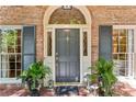 Elegant front entrance boasting a stylish door, decorative sidelights, and manicured potted plants at 4590 Lake Forrest Nw Dr, Atlanta, GA 30342