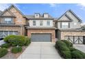 Two-story brick and stone townhome with gray garage doors and manicured landscaping at 5649 Cobblestone Creek Pl # 13, Mableton, GA 30126