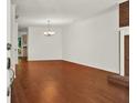 Spacious living room with hardwood floors, white walls, and a classic chandelier at 6190 Douglas Manor Ct, Douglasville, GA 30134