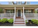 Inviting front porch with classic white railings and a brick facade with brown accents at 4940 Hanna Kate Ct, Cumming, GA 30028
