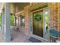 Charming brick porch with a decorative wreath on the front door and elegant outdoor seating at 3990 Old Spring House Ct, Atlanta, GA 30338