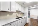 Bright kitchen with white cabinets, stainless sink and appliances with tile backsplash and updated countertops at 8827 Applegate Ln, Atlanta, GA 30350