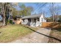Charming stone home boasting a freshly mowed lawn and a newly installed light colored wooden fence at 1441 Ezra Church Nw Dr, Atlanta, GA 30314