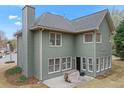 Rear exterior view of home showing green siding, patio, and multiple windows at 1803 Gold Finch Way, Lawrenceville, GA 30043