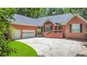 Brick house featuring a 3-car garage, lots of parking, and mature landscaping at 7350 S Mitchell Ct, Villa Rica, GA 30180