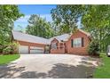 Charming brick home with a three car garage, mature trees, and expansive driveway at 7350 S Mitchell Ct, Villa Rica, GA 30180