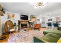Open-concept living room featuring a stone fireplace, modern lighting and hardwood floors at 1131 Hershey Dr, Marietta, GA 30062