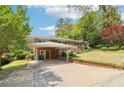 Brick home with a covered parking area, landscaped lawn, and brick retaining wall, all under a bright sky at 454 Jo Ann Se Dr, Marietta, GA 30067