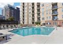 Community pool with lounge chairs, tables and umbrellas and a multi story building in the background at 325 E Paces Ferry Ne Rd # 810, Atlanta, GA 30305