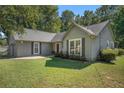 Charming single-story home with a landscaped front yard, gray siding, and a red front door at 5623 Yeager Ridge Dr, Douglasville, GA 30135