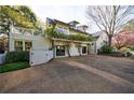 Charming home exterior featuring a spacious driveway, white picket fence, and second story deck at 202 Lakeview Ave, Atlanta, GA 30305