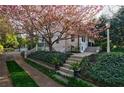Beautiful home entrance with stone steps, landscaped garden beds, and a blooming tree at 202 Lakeview Ave, Atlanta, GA 30305