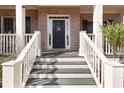 Inviting front porch steps lead to a brick facade with a dark front door and white railings at 4514 Heathrow Nw Ct, Kennesaw, GA 30152