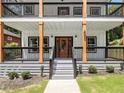 Charming home featuring a welcoming front porch with natural wood accents and a decorative front door at 490 Third Ave, Scottdale, GA 30079