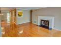 Bright living room featuring hardwood floors, a fireplace, and a view to the kitchen at 1005 Berkeley Woods Dr, Duluth, GA 30096