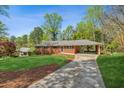 Traditional brick ranch with attached carport, manicured lawn, and inviting curb appeal at 681 Counsel Dr, Marietta, GA 30068