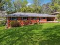 Charming brick home featuring a well-maintained lawn, dark shutters, and a convenient carport at 681 Counsel Dr, Marietta, GA 30068
