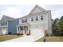 Stylish two-story home with gray siding, white trim, and a two-car garage with a concrete driveway at 7586 Jennadee Dr, Fairburn, GA 30213