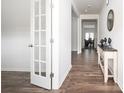 Bright foyer with wood flooring and an elegant console table and half glass door at 7586 Jennadee Dr, Fairburn, GA 30213