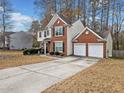Beautiful home featuring a two-car garage, long driveway, brick facade, and manicured landscaping at 184 Chamberlyn Ln, Hiram, GA 30141