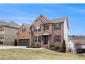 A well-maintained brick home showcasing a beautiful lawn, two-car garage, and classic design elements at 4604 Marching Ln, Fairburn, GA 30213