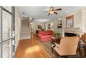 Inviting living room featuring hardwood floors, a cozy fireplace, and an open staircase at 4900 Fairmont Way, Roswell, GA 30075