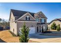 Exterior view of a brick house with a two car garage and a well-maintained lawn at 3835 Rifflepool Ct, Douglasville, GA 30135
