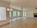 Bright and airy living room featuring hardwood floors, a fireplace, and many windows with natural light at 6120 Hutchins Dr, Buford, GA 30518
