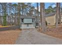Charming light blue home features a two-car garage and basketball hoop in a wooded suburban neighborhood at 670 Westbrook Pl, Lawrenceville, GA 30044