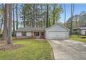 Charming single-Gathering home boasts a well-manicured front yard, driveway, and attached garage at 9053 Franklin Ct, Jonesboro, GA 30238