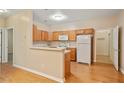 Bright kitchen featuring wood cabinets, hard wood floors, and white appliances at 460 Tribble Gap Rd # 1004, Cumming, GA 30040
