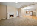 Open-concept living area with fireplace, carpet flooring, and seamless flow to the bright kitchen at 460 Tribble Gap Rd # 1004, Cumming, GA 30040