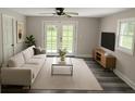 Bright living room with hardwood floors, a modern sofa, and access to the backyard at 1956 Shirley Sw St, Atlanta, GA 30311